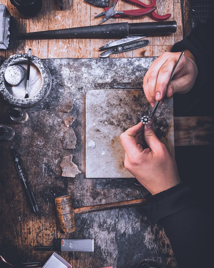 Il banco di lavoro del laboratorio con attrezzi e gioielli in lavorazione